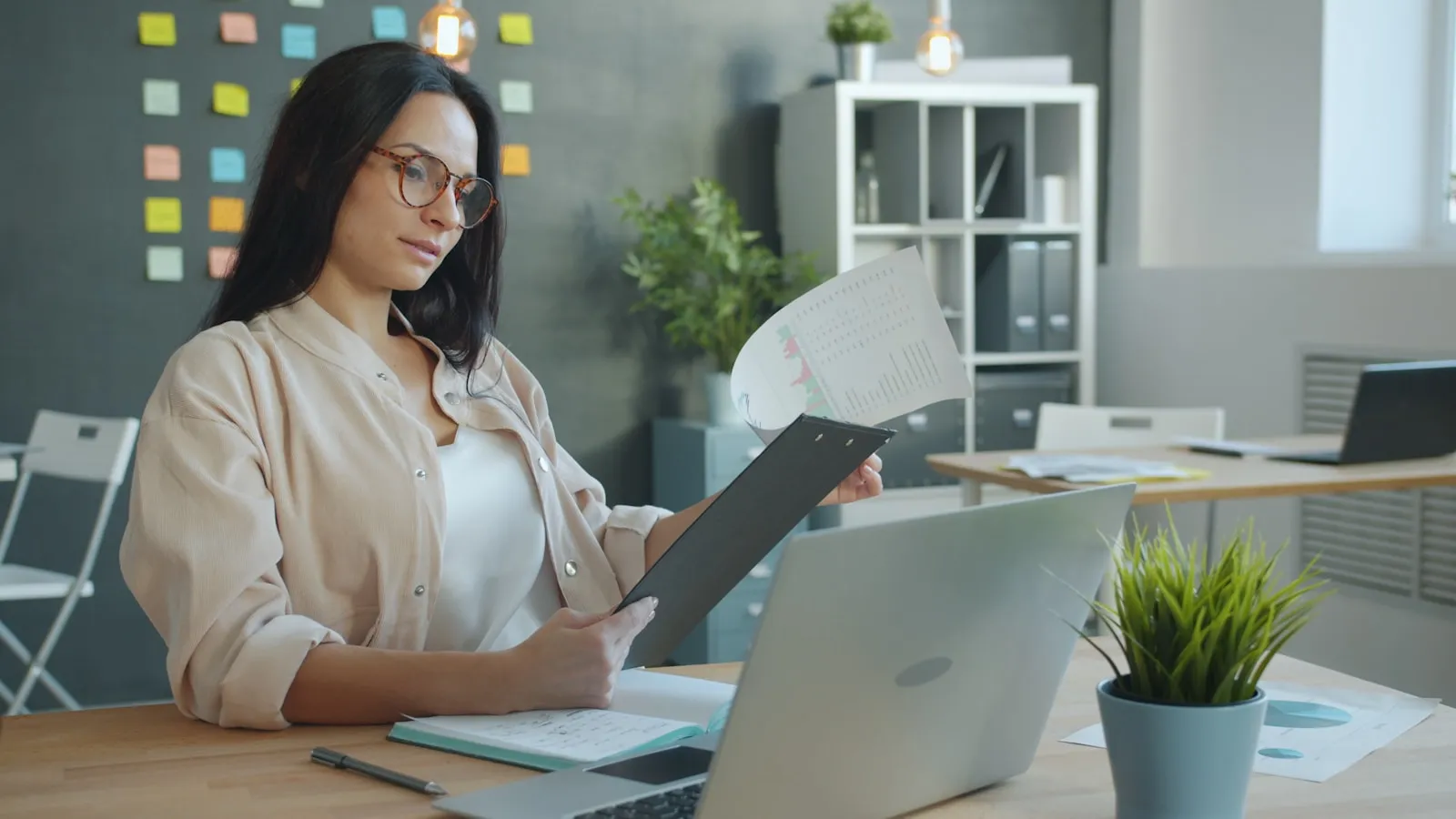Une dirigeante de PME étudie un devis chiffré devant son ordinateur portable dans un bureau lumineux