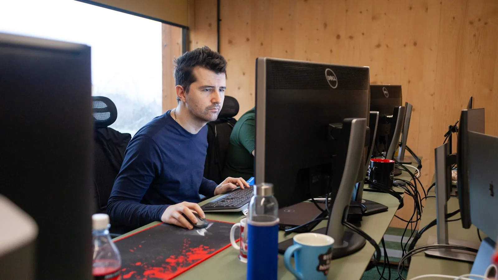 Un développeur concentré devant ses écrans dans un bureau
